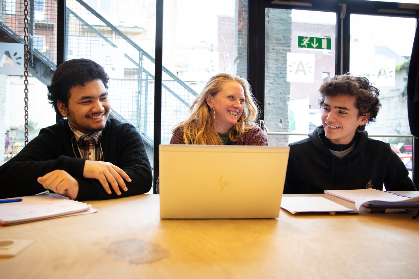 drie mensen achter laptop